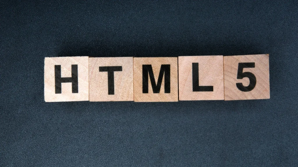 HTML5 web development services represented with wooden letter blocks spelling HTML5 on a dark background