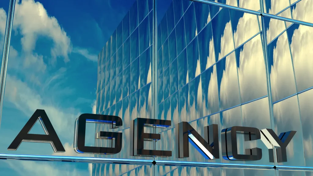 A reflective glass building with the word 'AGENCY' highlighting the importance of SEO for digital marketing agencies to improve visibility and branding
